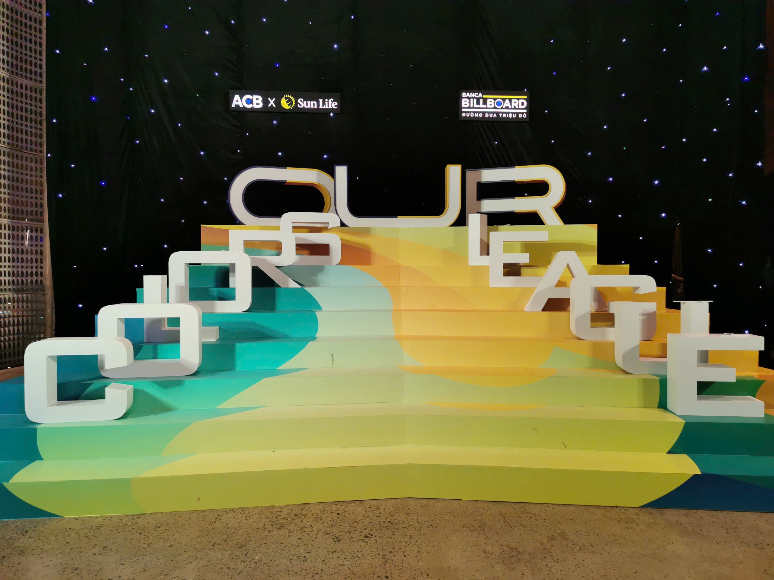 Large colorful stage setup spelling out words with bold sculptural forms
